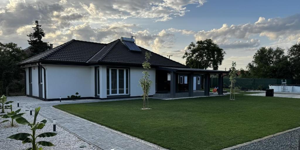a house with a green lawn in front of it at Silver Chill Apartman in Abádszalók