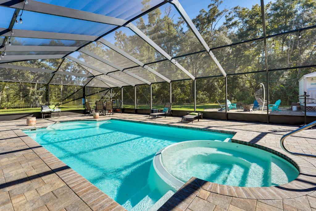 an indoor swimming pool in a glass house at Suwannee River Retreat Pet Friendly, Private Dock in Branford