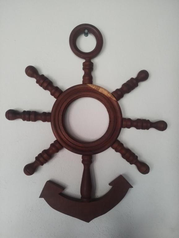 een houten wiel met een spiegel aan de muur bij Colibríes Dorados in Mar del Plata