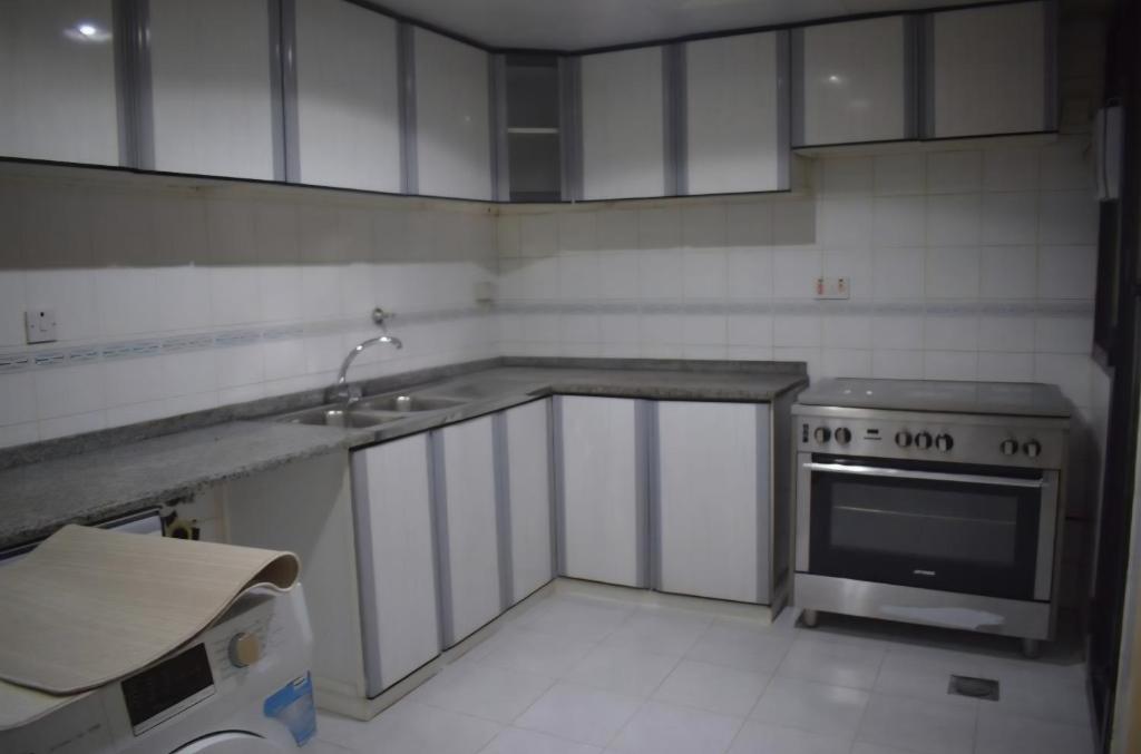 a small kitchen with a stove and a sink at Your home stay in Abu Dhabi