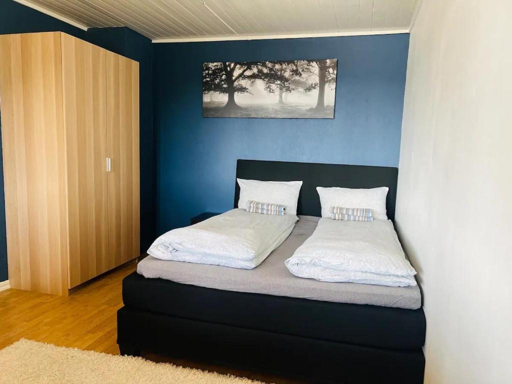 Un dormitorio con una cama con una pared azul. en House in Rotnes, Nittedal, en Nittedal