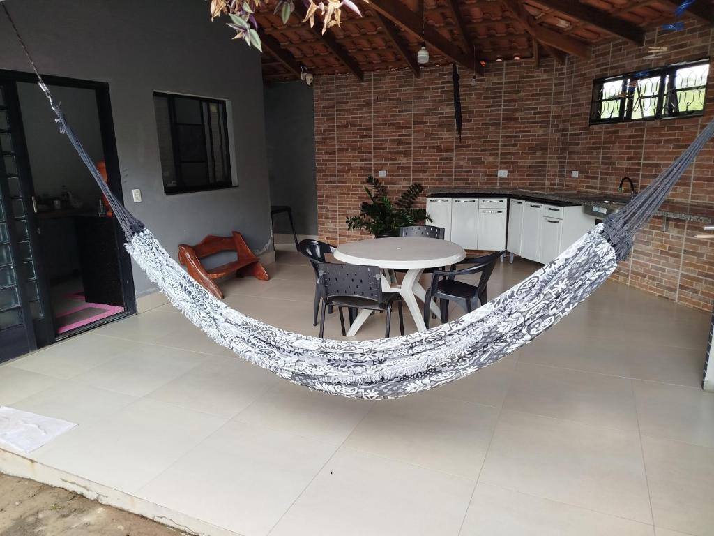 eine Hängematte in einem Raum mit Tisch und Stühlen in der Unterkunft Casa refúgio da paz in Pirenópolis