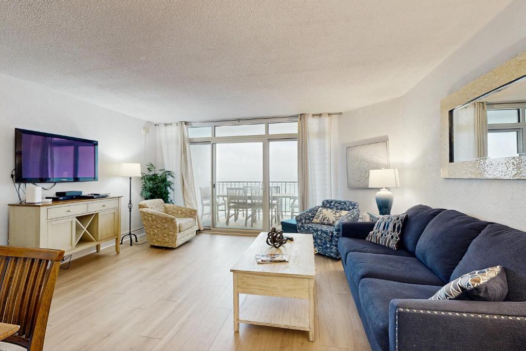 a living room with a blue couch and a tv at Pyramid 8K in Ocean City