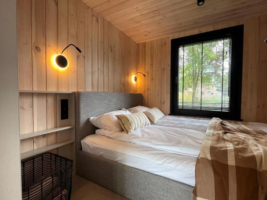a bedroom with a bed in a wooden cabin at Bay Zatoka Radzyń in Radzyń