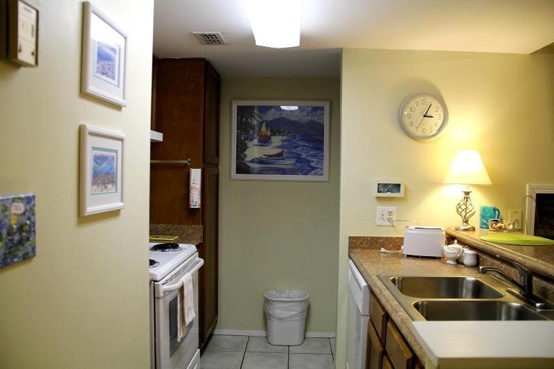 uma cozinha com um lavatório e um relógio na parede em Sugar Beach 312 em Gulf Shores