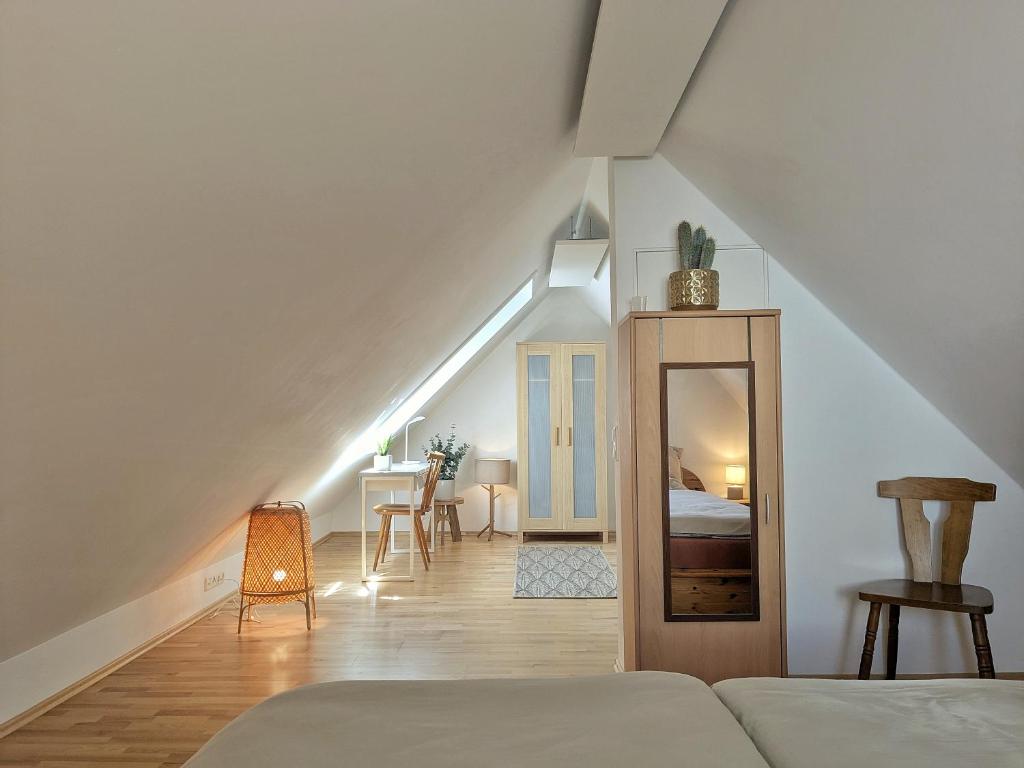 a attic bedroom with a bed and a table at Cosy cottage in the countryside near Landsberg in Schwifting
