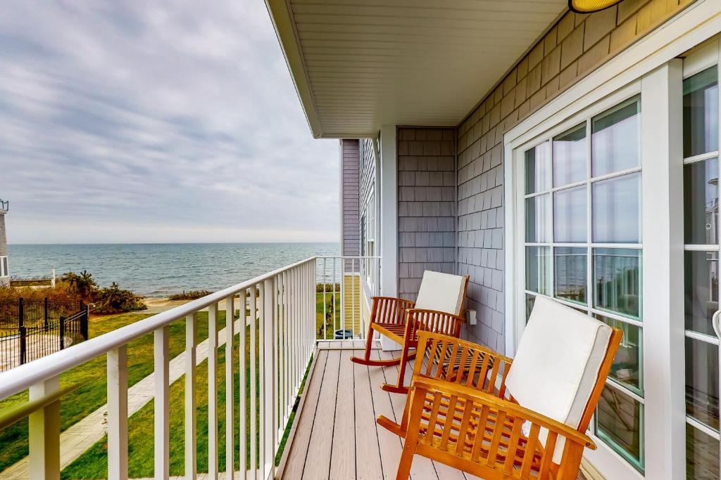a balcony with chairs and a view of the ocean at Ocean Peace in Dennis Port