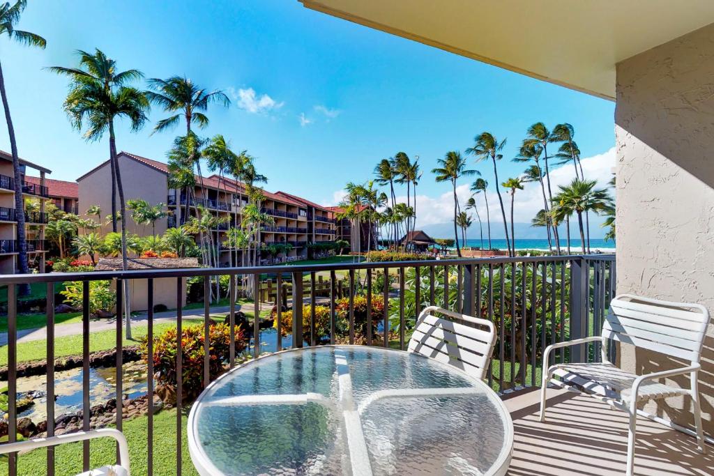 a balcony with a table and chairs and the ocean at Papakea Resort C204 in Honokowai