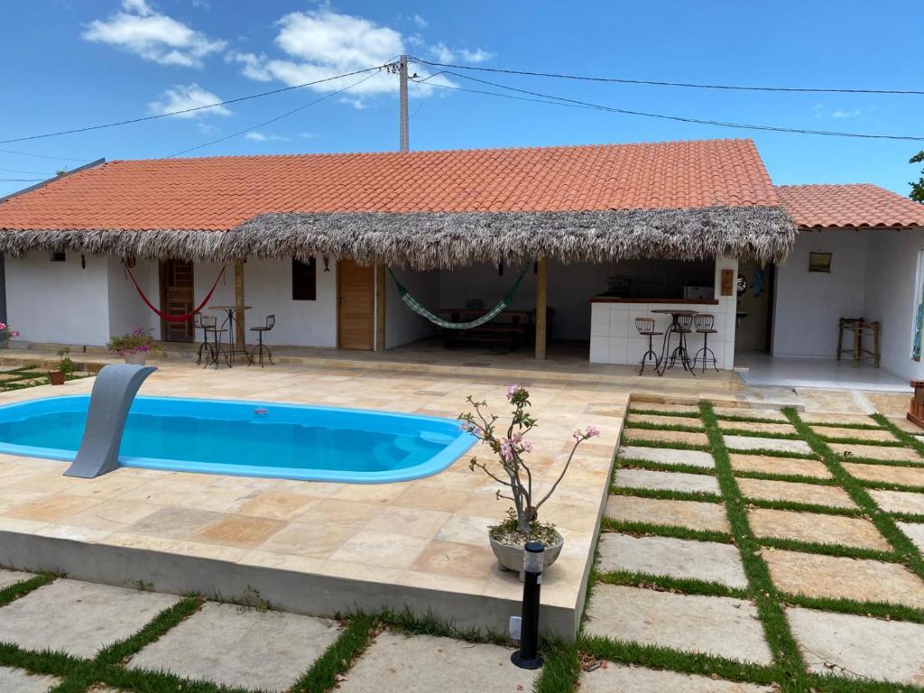 a villa with a swimming pool in front of a house at Brisa Mansa in Barra Grande