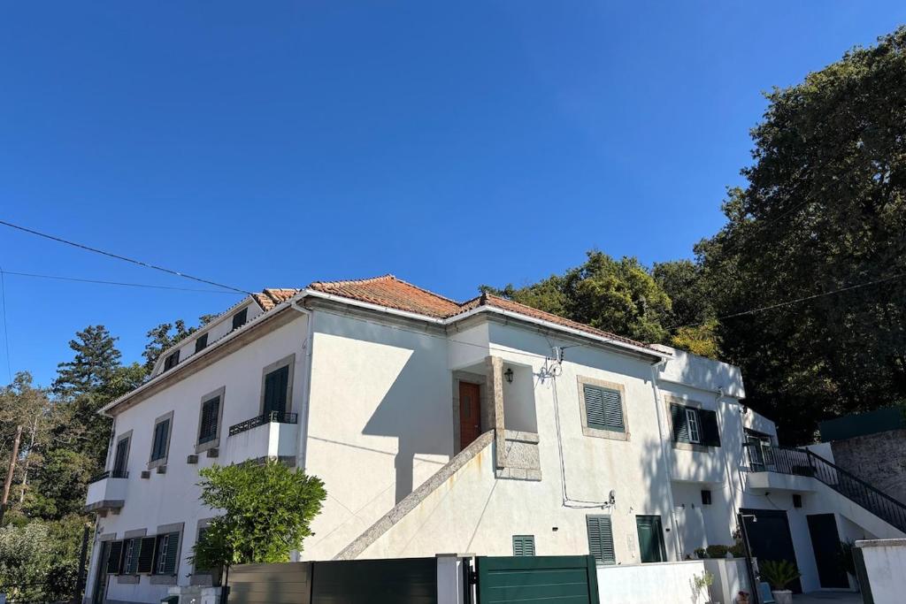 a white building with a red roof at Gouveia Forest Guest House in Gouveia