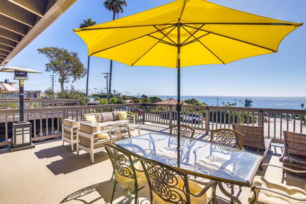 een patio met een tafel en een gele parasol bij Steps to Sand and Surf! Snowbird Haven in Malibu in Solromar