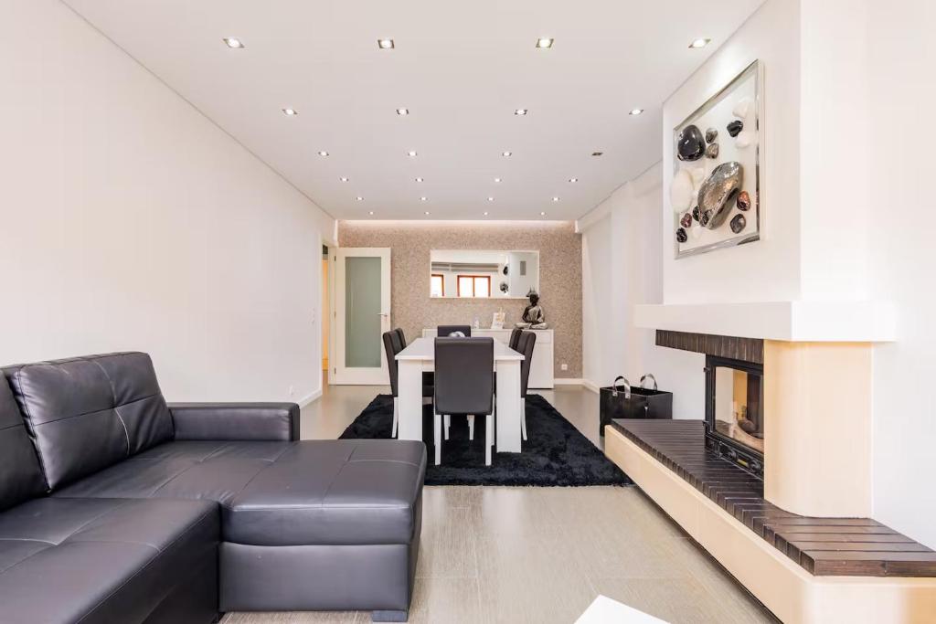 Una sala de estar con un sofá y una chimenea. en Refugio dos Beijinhos, en Leça da Palmeira