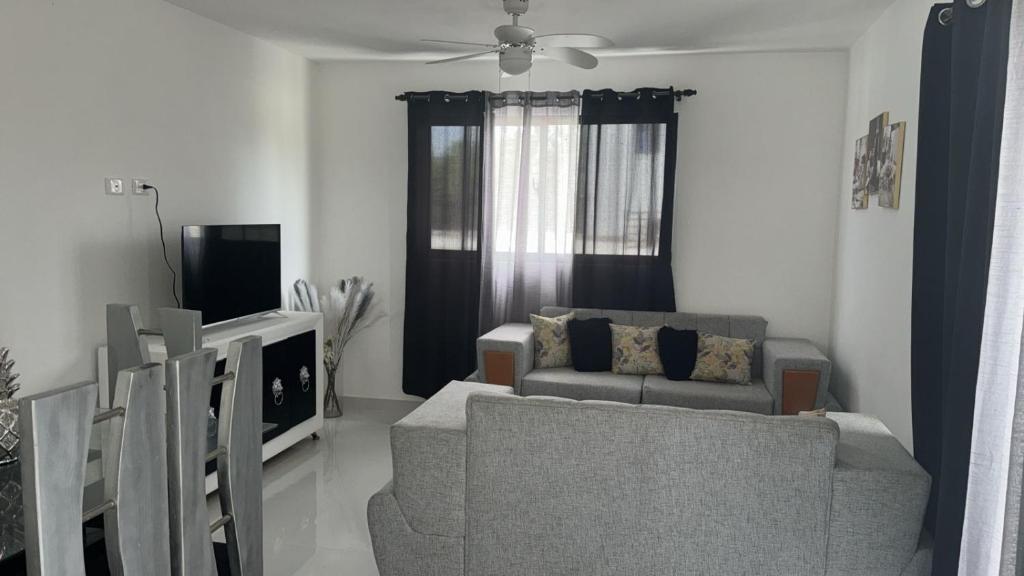 a living room with a couch and a tv at Residencial HH in Santiago de los Caballeros