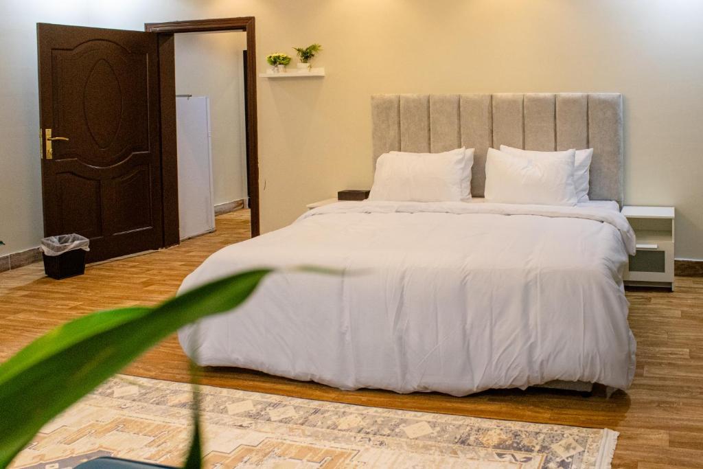 a bedroom with a large bed with white sheets and pillows at Waha Grand Residance in Medina