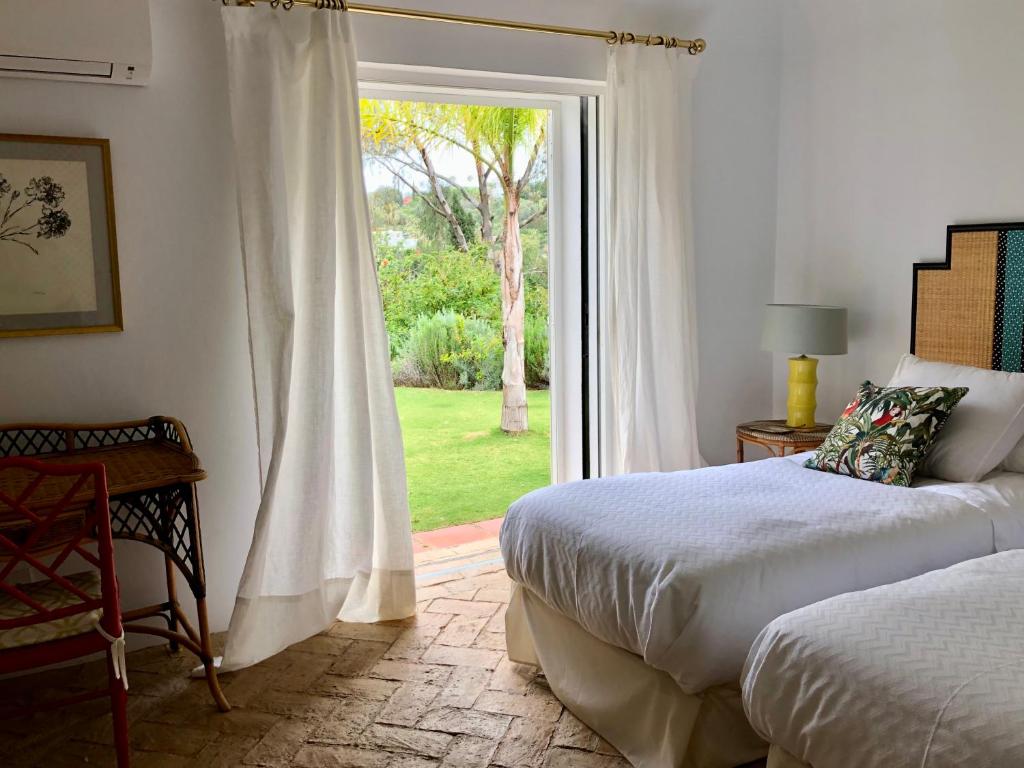 ソトグランデにあるPatio Room Sotograndeのベッドルーム1室(ベッド2台付)、スライド式ガラスドアが備わります。