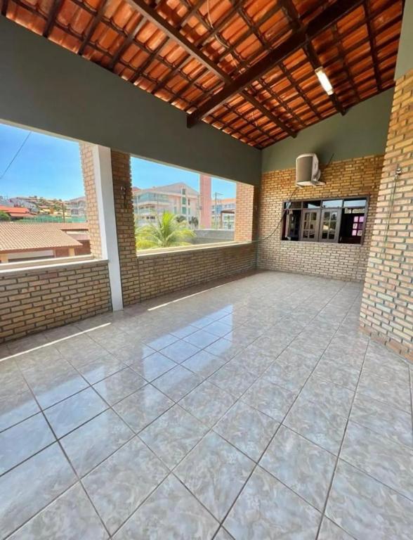 a large room with a large tile floor and windows at Casa em porto da dunas in Aquiraz