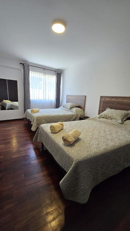 a room with three beds with towels on them at Garzonier in the best area of Cochabamba in Cochabamba