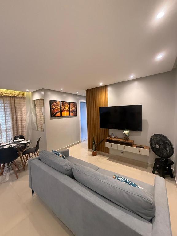a living room with a large couch and a flat screen tv at COP30 - Apartamento completo para alugar in Ananindeua
