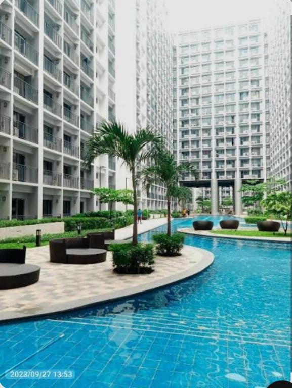 马尼拉Overnight @ Shakhbot's的一座棕榈树和建筑的大型游泳池