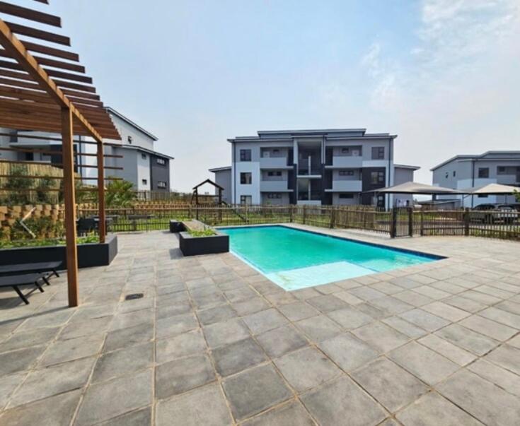 a swimming pool in front of a building at Bliss Ballito 2 in Ballito