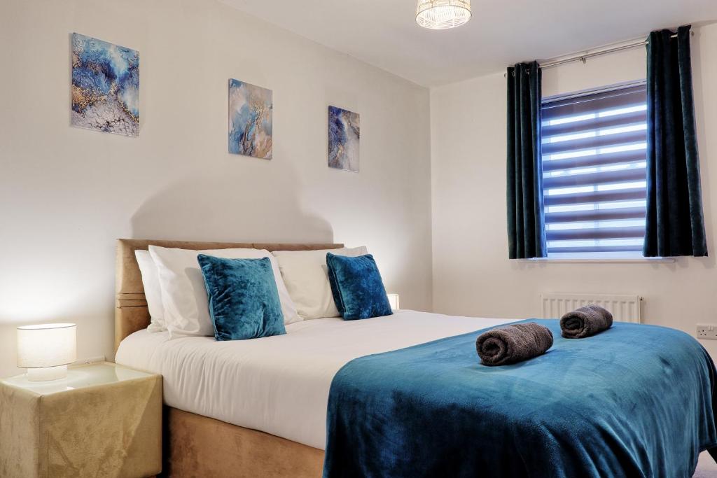 a bedroom with two beds with blue sheets and a window at Spacious 4BR Townhouse, Sleeps 9, Fast WIFI, FREE PARKING, Contractor friendly in Colchester