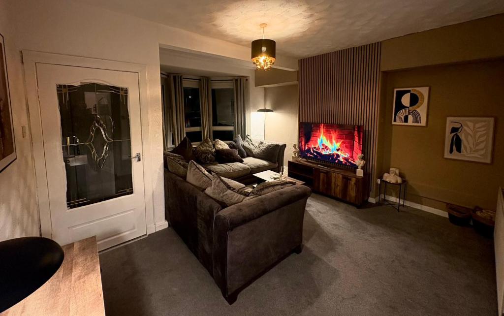 a living room with a couch and a tv at Cozy corner-Sleeps 8 guest Entire house Glasgow very central in Glasgow