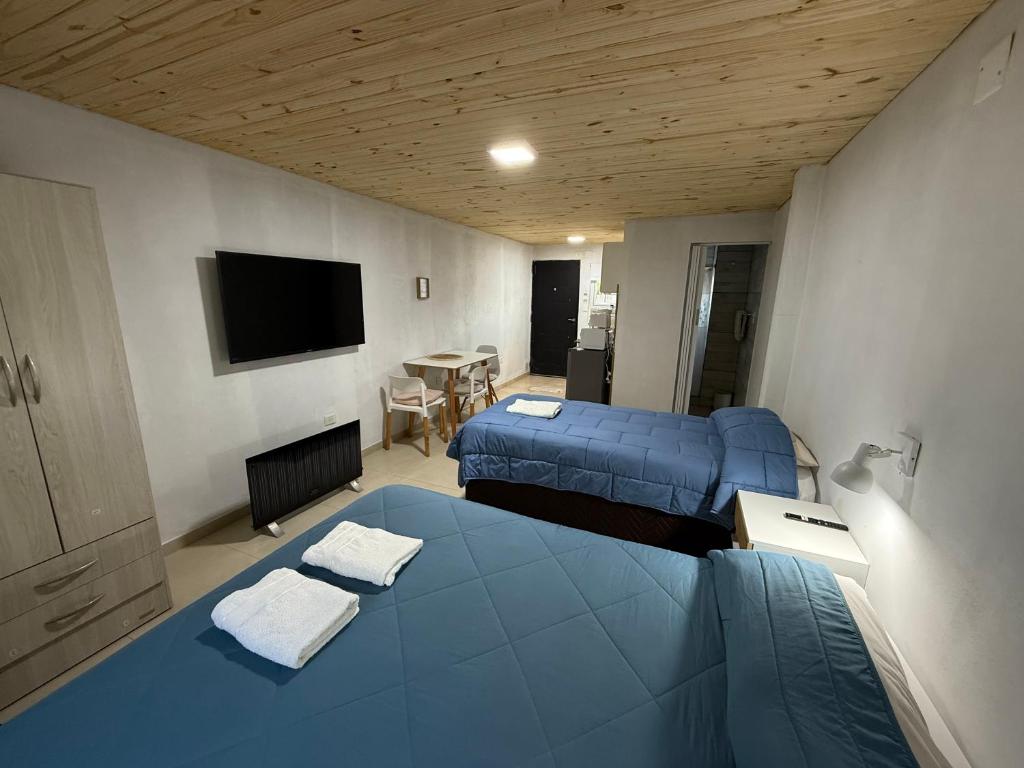 - une chambre avec 2 lits, une télévision et une table dans l'établissement La Cascaruda Suites y Deptos, à Perito Moreno