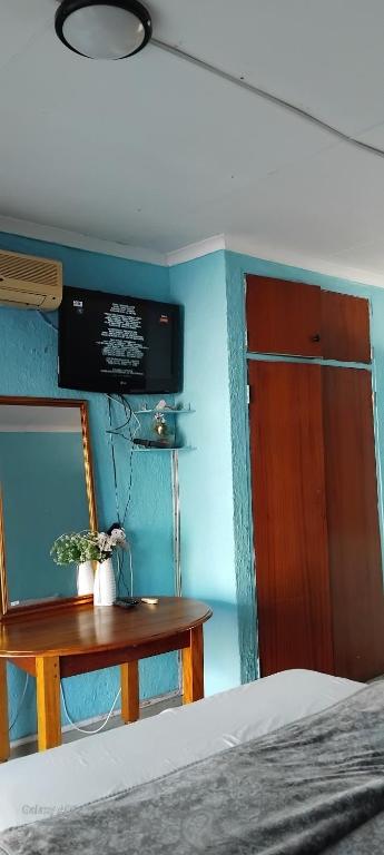 a bedroom with a bed and a table with a mirror at Platinum Palace Guest House in Rustenburg