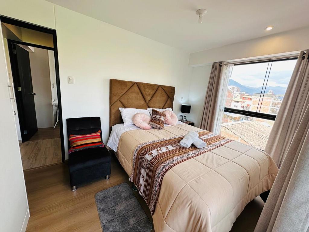 a bedroom with a large bed with a large window at Departamento Centrico en Cusco in San Antonio