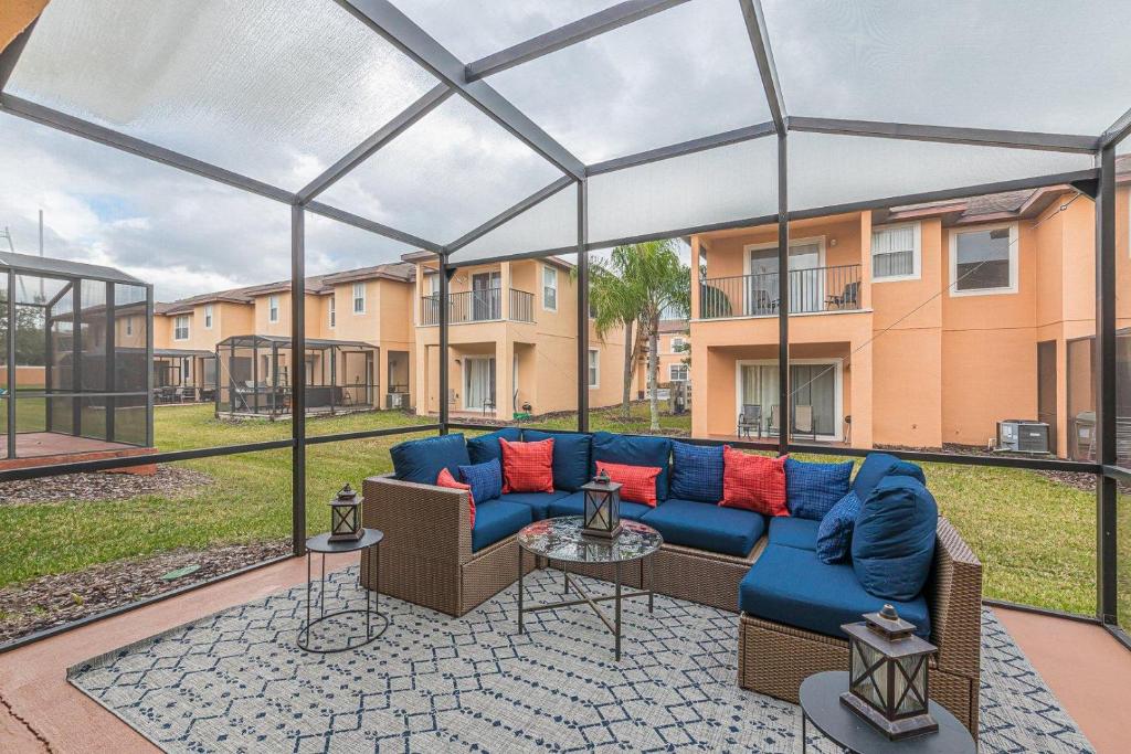 a patio with a blue couch in front of a building at 2711 - Jungle Book Bungalow - DO NOT DO in Orlando