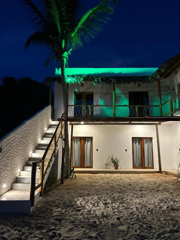 a house on the beach at night at Maré alta in Guriú