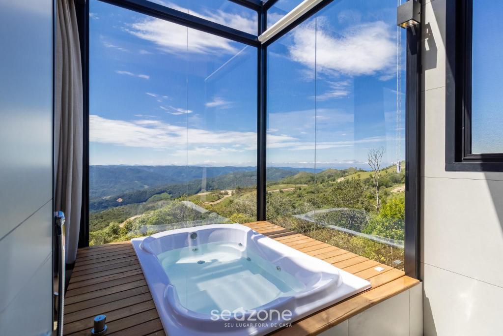 Cabana romântica com vista na serra VST038 في São Paulo dos Pinhais: حوض استحمام في غرفة ذات نافذة كبيرة
