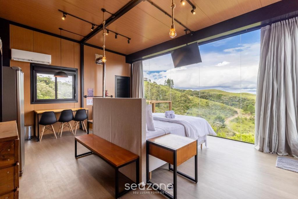 a bedroom with a bed and a large window at Charmoso chalé com lareira e hidro! VST034 in São Paulo dos Pinhais