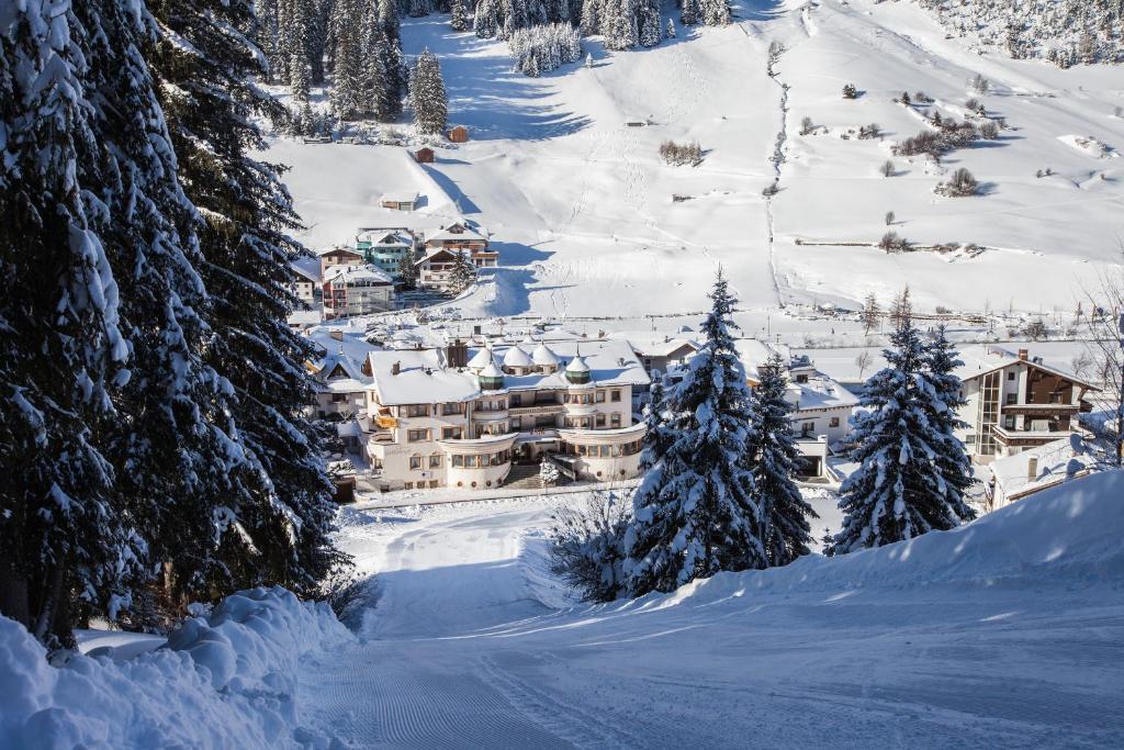 a resort on a snowy mountain with snow covered trees at Hotel Schlosshof in Ischgl