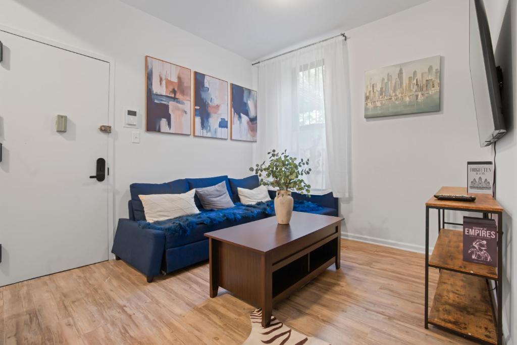 a living room with a blue couch and a table at 2BD Comfy Manhattan Home in New York
