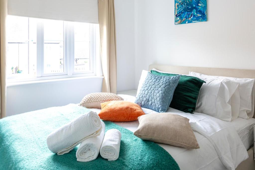 a bed with towels and shoes on top of it at Peaceful 2BR Retreat w Garden Near Oxford in Witney