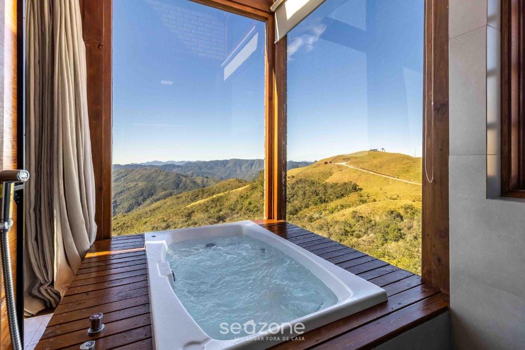 bañera en una habitación con vistas a la montaña en Espectacular cabaña en la región montañosa VST008, en São Paulo dos Pinhais
