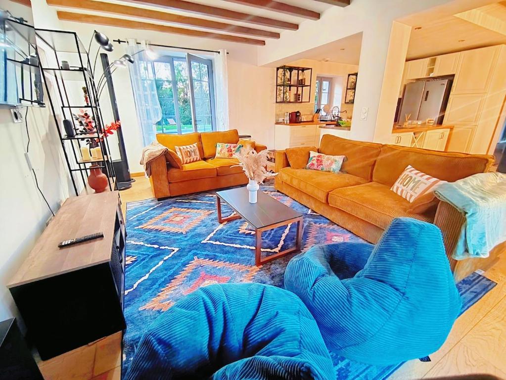 a living room with a couch and a table at Felicità - Longère with swimming pool and large garden in Poulaines