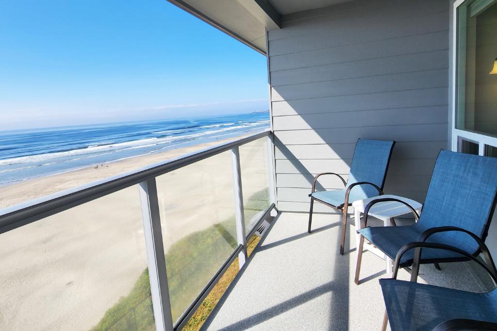 a balcony with two chairs and the beach at Nye Beach Ocean Front Condo! Ocean Memories in Newport