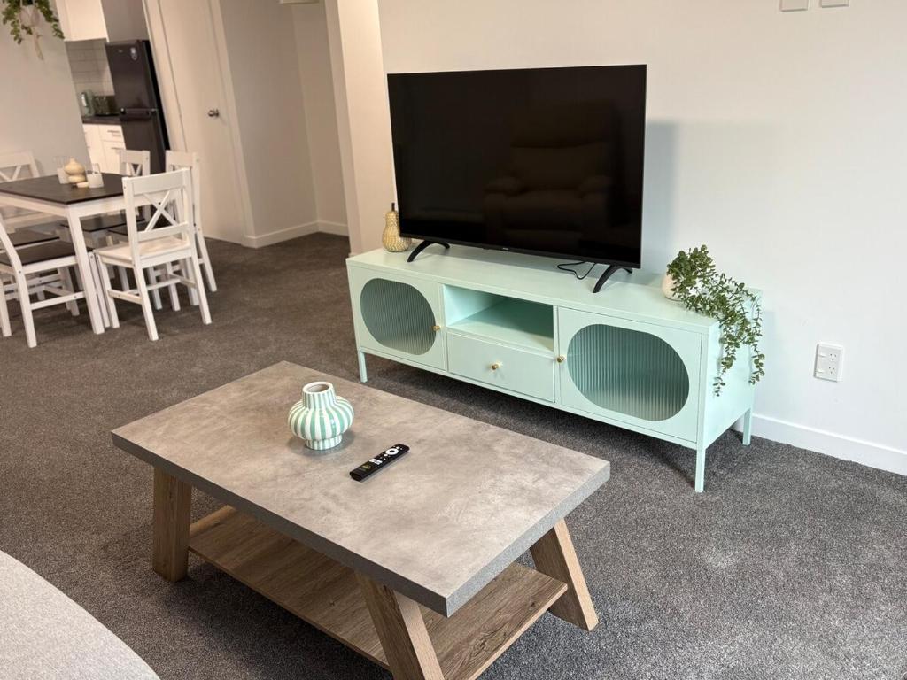 a living room with a tv and a coffee table at Space, Style and Serenity in Lower Hutt