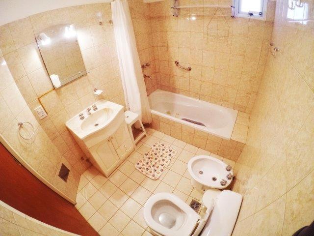 a bathroom with a toilet and a sink and a bath tub at Edymar in Puerto Madryn