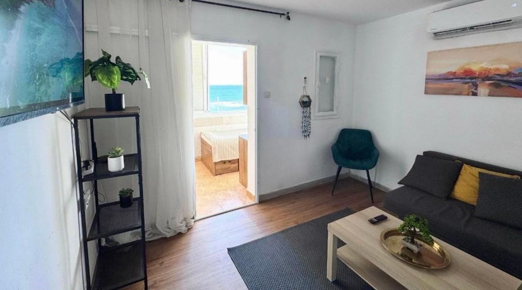 a living room with a couch and a table at Seaside Vacation in Haifa
