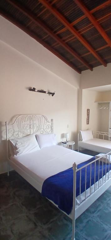 Un dormitorio con una gran cama blanca con sábanas azules. en Sam'S VIP Hostel San Gil, en San Gil