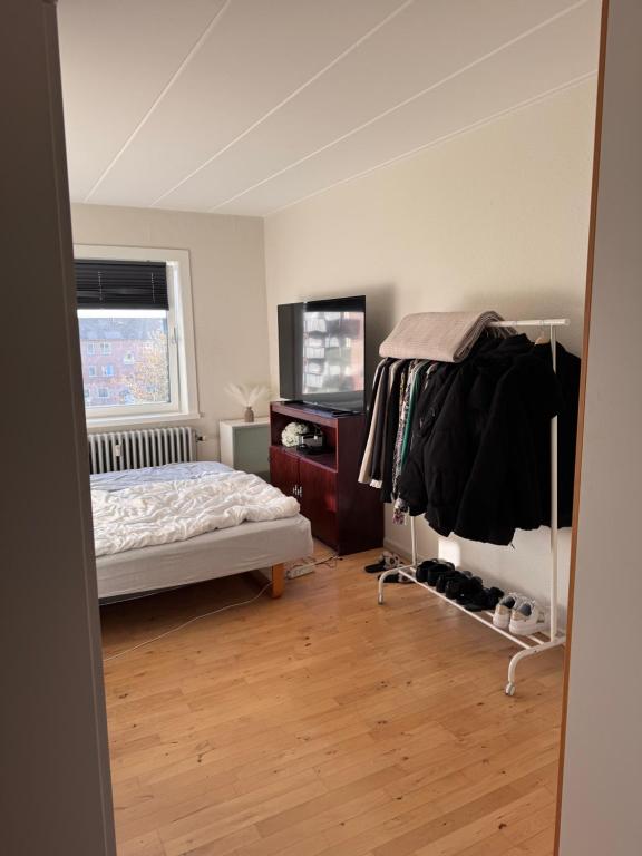 ein Schlafzimmer mit einem Bett, einer Kommode und einem Fernseher in der Unterkunft Lekker leilighet i Thisted in Thisted