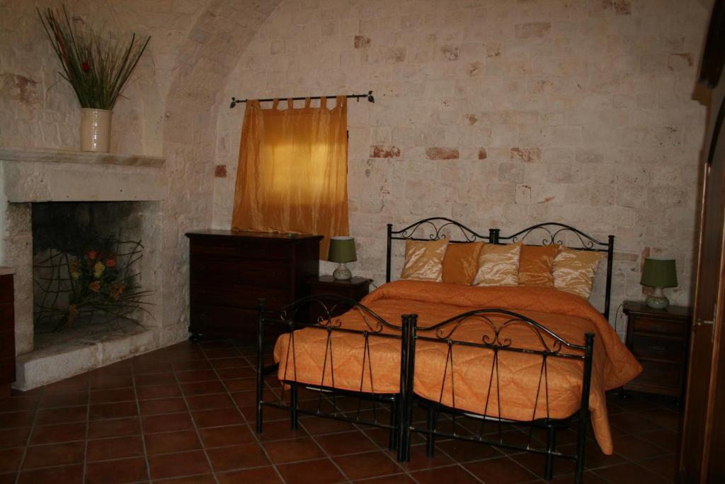 カステッラーナ・グロッテにあるMasseria La Luna Nel Pozzoのベッドルーム(ベッド1台、暖炉付)
