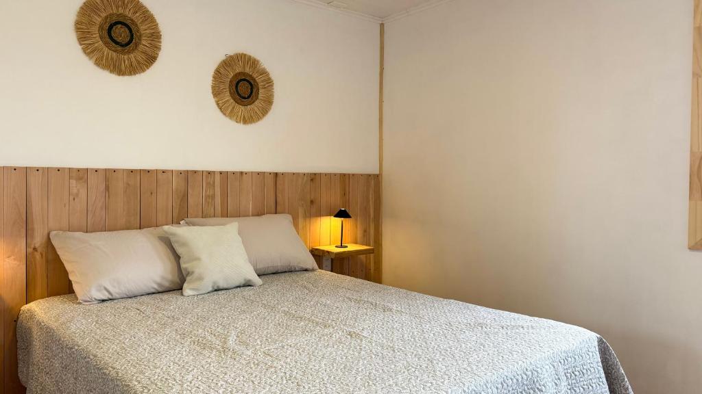 a bedroom with a bed with a white comforter at Eco-Bungallow in Puerto Natales