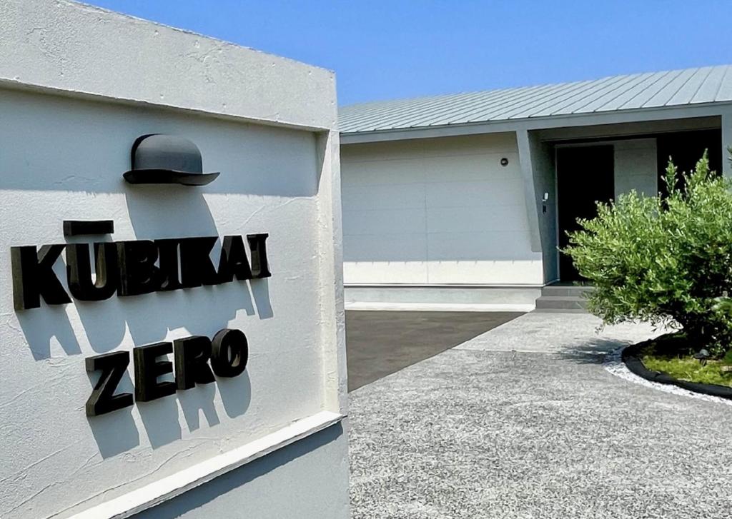een huis met een bord waarop staat: Kruzman Zero bij Kubikai in Itoshima