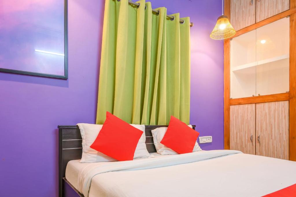 a bedroom with a bed with red and green curtains at Hotel O DREAM INN in Khandagiri