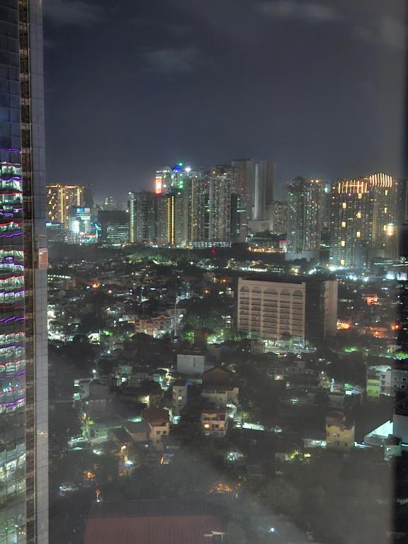 a view of a city at night with lights at Mysuites2go24K Parksuites T2 in Manila