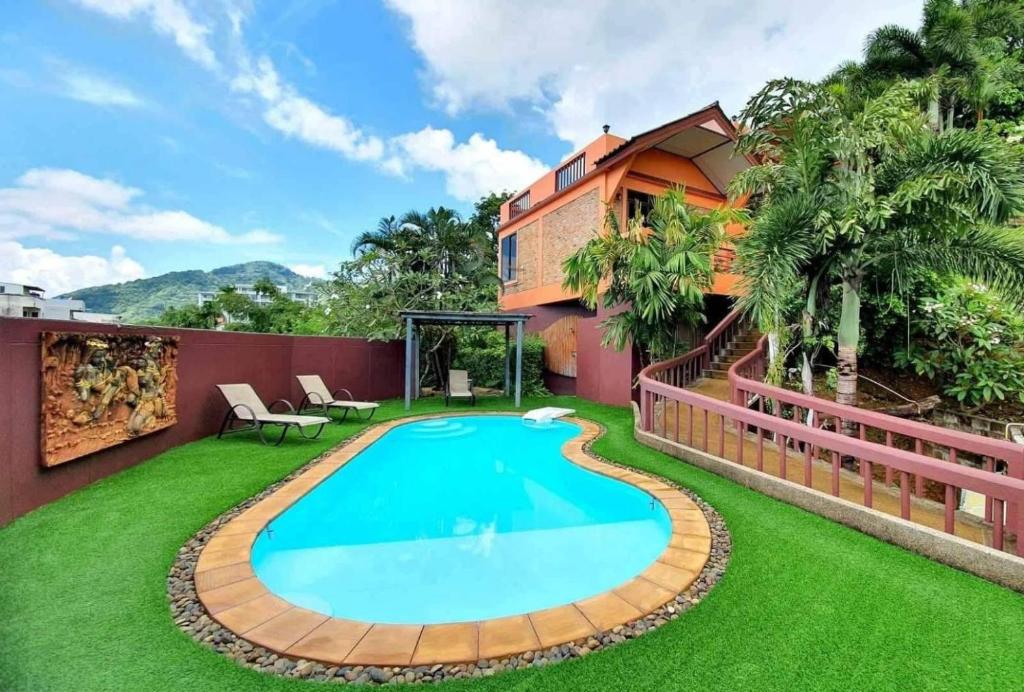 a swimming pool in the backyard of a house at The Cozy House in Karon Beach